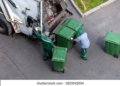 Garbage Men Loading Household Rubbish In Garbage Truck, View From Above