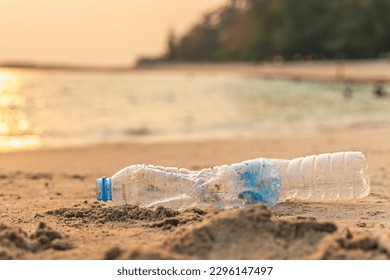 Garbage on beach. Empty use dirty plastic bottle and cap. Environmental pollution. Waste Plastic on beautiful sea.