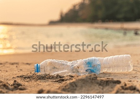 Garbage on beach. Empty use dirty plastic bottle and cap. Environmental pollution. Waste Plastic on beautiful sea.