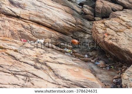 A lot of garbage on beach rock