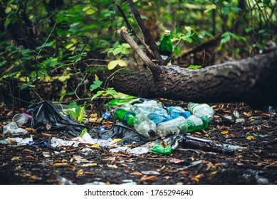 Garbage pile in forest among plants. Toxic plastic into nature everywhere. Rubbish heap in park among vegetation. Contaminated soil. Environmental pollution. Ecological issue. Throw trash anywhere. - Shutterstock ID 1765294640