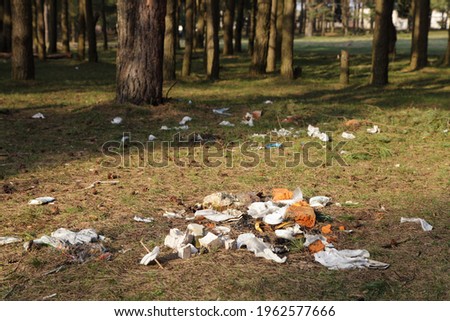 Garbage pile on the countryside Park forest edge on green trees background on a Sunny spring day, plastic littering the wildlife with vacationers people in Europe