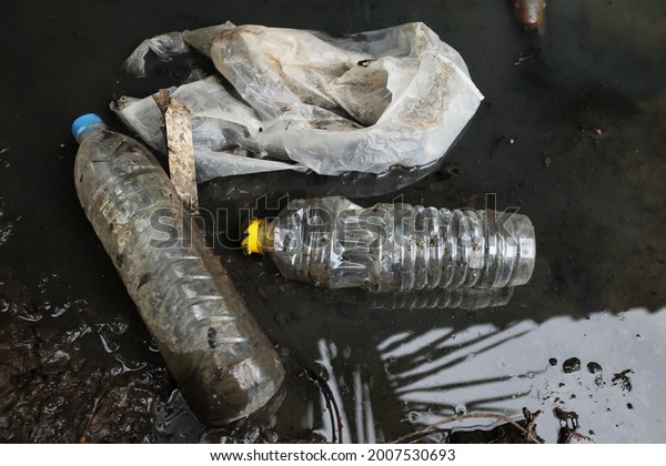 Garbage, plastic\
scraps and plastic water bottles float in sewage water.pollution\
and environment\
concept