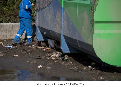 Garbage Removal Men Working For A Public Utility Emptying Trash Container