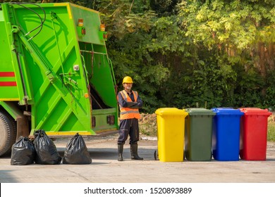 Garbage Removal Worker In Protective Clothing Working For A Public Utility Emptying Trash Container.