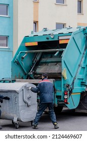 A Garbage Truck Picks Up Garbage In A Residential Area. Workers Load A Container With Garbage. Separate Collection And Disposal Of Garbage