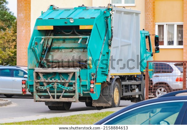 A garbage truck\
picks up garbage in a residential area. Loading mussar in\
containers into the car. Separate collection and disposal of\
garbage. Garbage collection\
vehicle