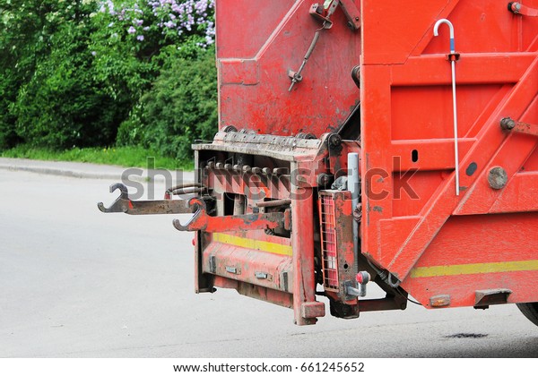 The garbage\
truck is prepared to receive a\
bin