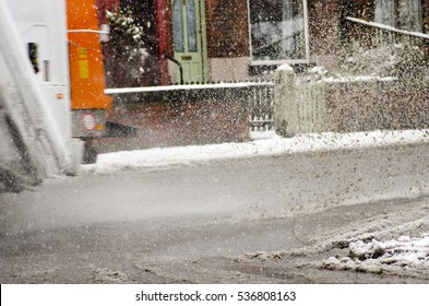 Garbage Truck Rides On Big Puddle In Snowy Day. Sleet Splash On A Manchester's Road.England 