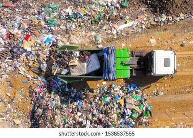 Garbage Truck Unloading At A Municipal Landfill, Top Down Aerial Image.