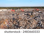 Garbage truck unloads rubbish in landfill. Landfill with waste disposal, Garbage dump. Reduce greenhouse, methane emissions. Mustard gas among toxic waste in landfill. Landfill garbage truck.