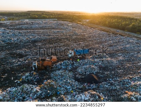 Garbage truck unloads rubbish in landfill. Landfill waste disposal. Garbage dump with waste plastic and polyethylene. Reduce greenhouse gas emissions and methane emissions. Environmental protection.