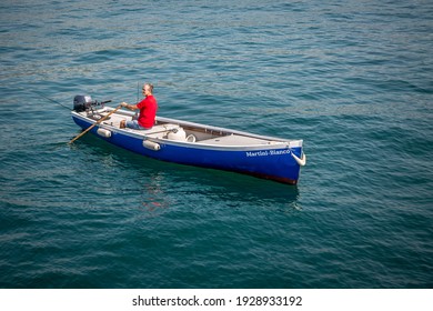 GARDA, ITALY 14 SEPTEMBER 2019: A Man On A Boat Ride On The Oars, On Lake Garda. Veneto, Italy