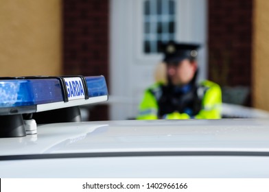 Garda Siochana Irish Police Officer Behind A Car