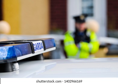 Garda Siochana Irish Police Officer Behind A Car