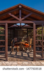 
Garden Arbor Made Of Wood, Natural Wood, Shadow Protection From Sunlight, Garden Furniture, Fruits On The Table.