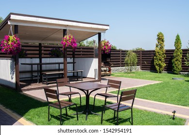 Garden Or Backyard Outdoor Pavilion With Wood Pergola, Bar Counter, Brick Oven, Fireplace And Barbecue For Cookout Food. Summer Party Place. Green backyard