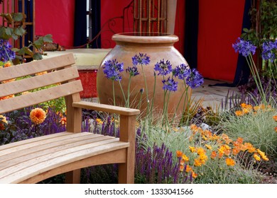 Garden Bench And Terracota Pot And Agapanthus In A Garden Design