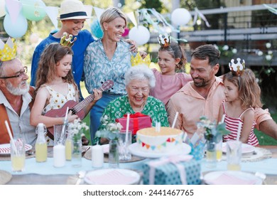 Garden birthday party for senior lady. Beautiful senior birthday woman receiving gift from family. - Powered by Shutterstock