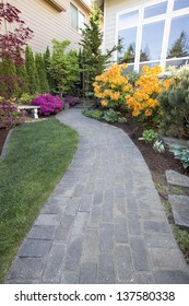 Garden Brick Paver Path Walkway With Green Grass Lawn And Landscaping Plants