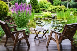 Garden Chairs Near The Pond In A Beautiful Garden