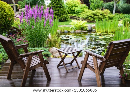 Garden chairs near the pond in a beautiful garden