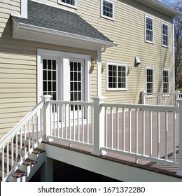 Garden Deck And French Doors, Detail. Champagne House Siding, Red Brown Boards, White Railings.