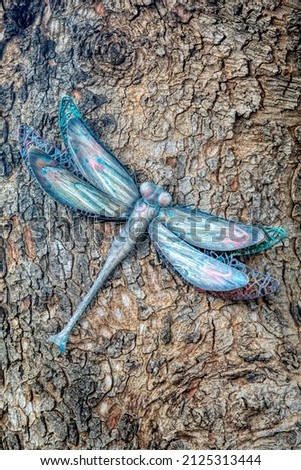 garden decoration, metal dragonfly hanging on a tree 