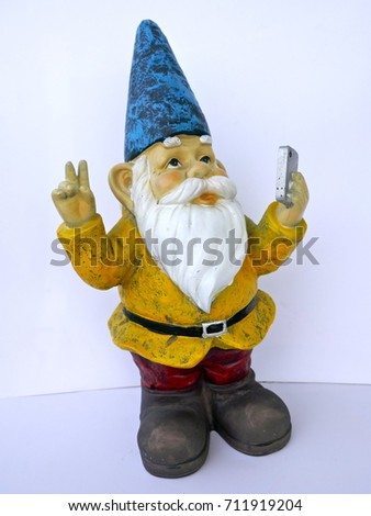 Garden dwarf with mobile phone makes peace sign  isolated on white background