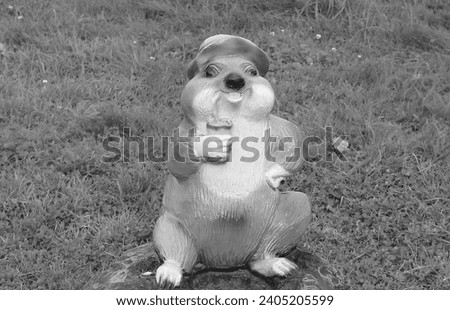 Garden figures of brown funny beaver in the park. Decorative plaster sculpture. Black and white photo.