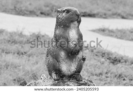 Garden figures of brown funny beavers in the park. Decorative plaster sculpture. Black and white photo.