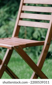 Garden Furniture Advertising Concepts. Wooden Lounge Chair Standing On Backyard At Green Blurred Background. Close Up View Of Yard Furnishing