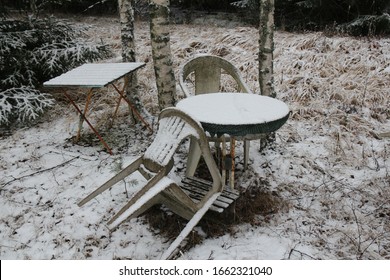 Garden Furniture In The Old, Abandoned Garden In The Snow In Winter.