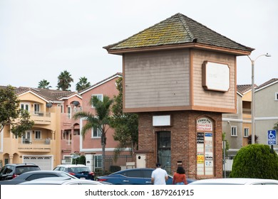 Garden Grove, California, USA - October 23, 2020: Pedestrians In A Parking Lot Walk Past A Shopping Center Tower.