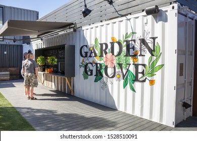 Garden Grove, California/United States - 10/11/2019: People Order Food At A Food Vendor Window At SteelCraft Garden Grove, Featuring A City Mural On A Shipping Container.