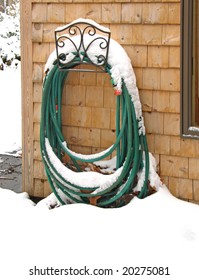 Garden Hose In Decorative Holder, Topped By Winter Snow