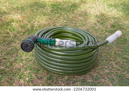 Garden hose green lawn new gardening equipment wrapped up coiled