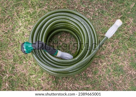 Garden hose green lawn new gardening equipment wrapped up coiled