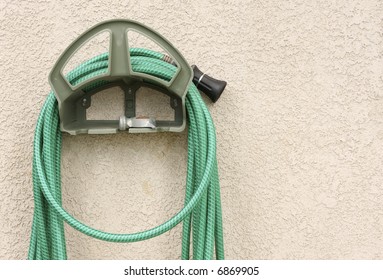 Garden Hose Hanging On Stucco Wall