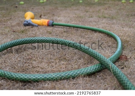 Similar – Image, Stock Photo Garden hose lies on a square terrace of stone tiles in a well-kept garden with lawn and a planting strip
