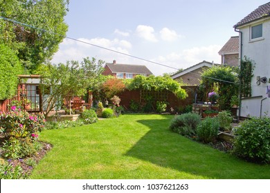 A Garden Lawn, Bordered With Shrubs, In A Rural Property In England.