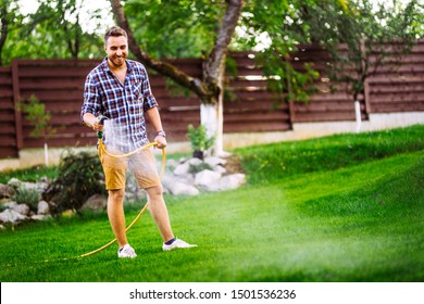 Garden Maintainance- Smiling Man, Happy Man With Hose And Watering The Lawn