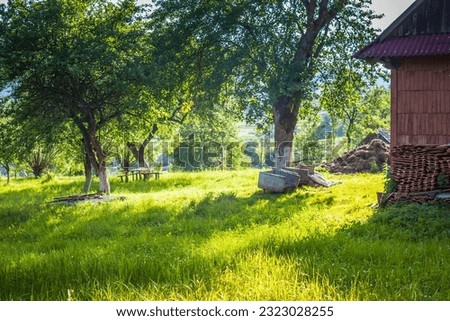 Garden near a house in a village in the mountains. Sheaves of hay and fields in a Ukrainian village in the Carpathians in spring. Village between mountains and sheaves of hay.