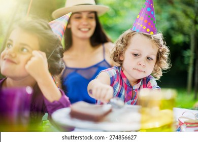 Garden Party, Greedy Little Girl Eating Chocolate Birthday Cake In Family