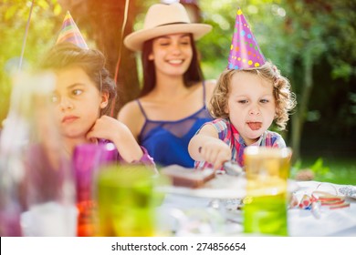 Garden Party, Greedy Little Girl Eating Chocolate Birthday Cake In Family