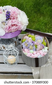 Garden party table: box of sweets and bouquet of flowers - Shutterstock ID 370889300