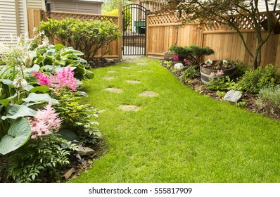 Garden Path. Back Yard Path Leads Past Garden In Bloom During Transition From Spring To Summer.