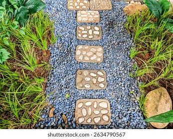 A garden path made of rectangular stepping stones laid on small gravel