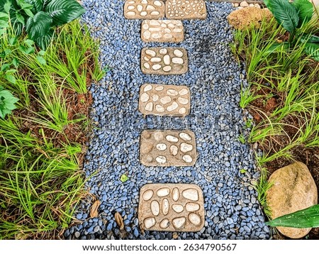 A garden path made of rectangular stepping stones laid on small gravel