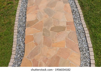 Garden Path With Natural Stone Slabs And Edging Made Of Paving Stones